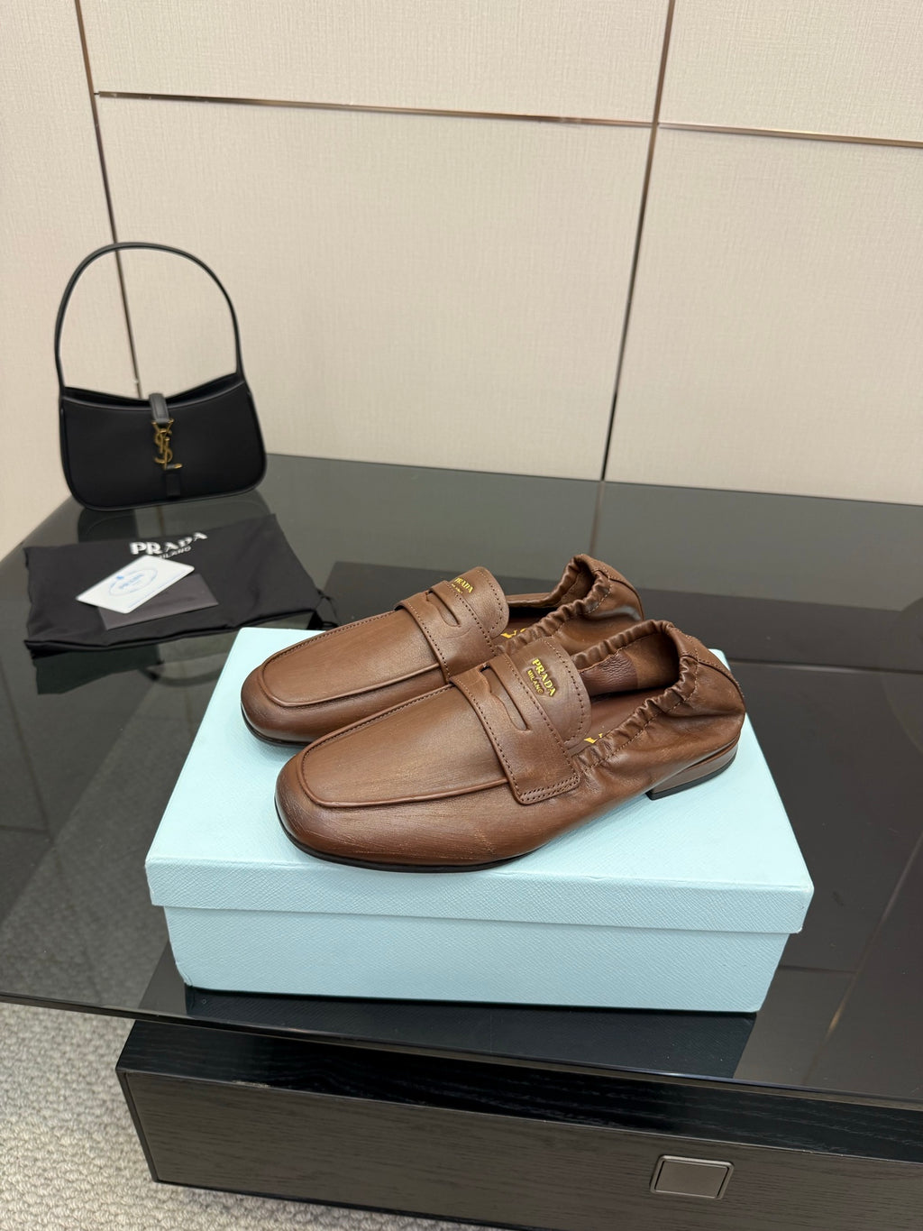 Brown leather loafers with strap over vamp and stitched upper detail, slip-on style