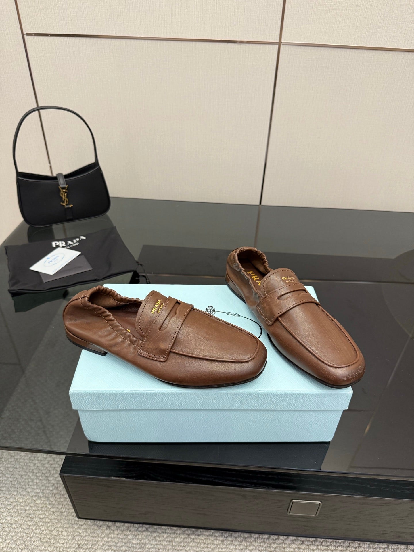Tan leather loafers pair, rounded toe slip-on with stitched apron and strap detail