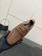 Tan leather loafer with Prada logo patch on strap, side view close-up