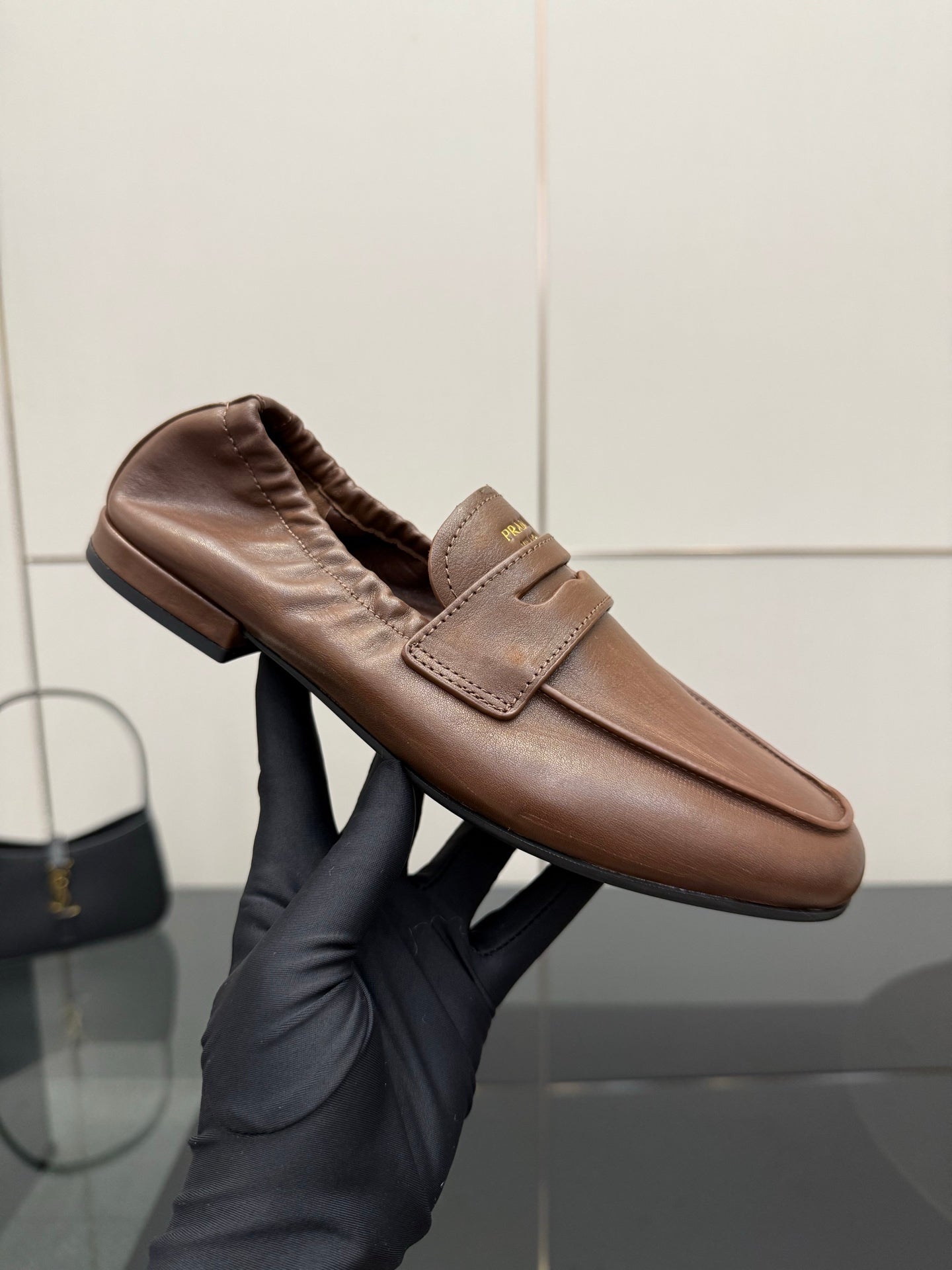 Tan leather loafer close-up on glove, top strap detail with gathered collar