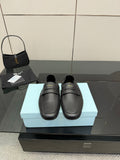 Black leather loafer with front strap, gold logo detail, flat sole