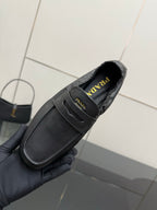 Black leather slip-on loafer close-up with side logo on insole