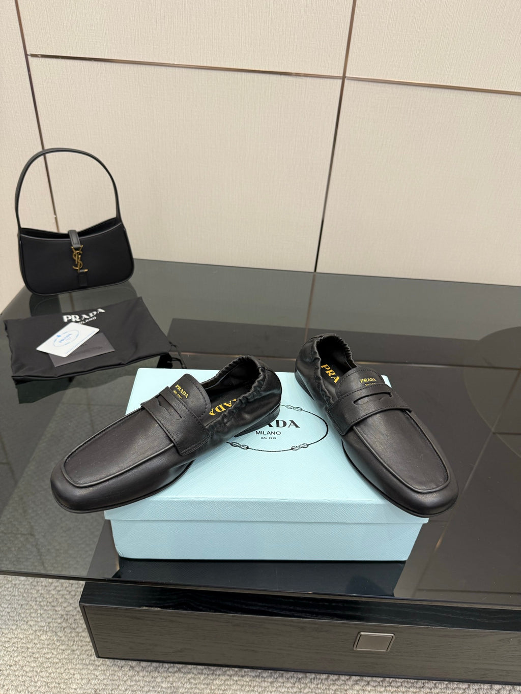 Black leather loafers with front strap and stitched seams, flat heel
