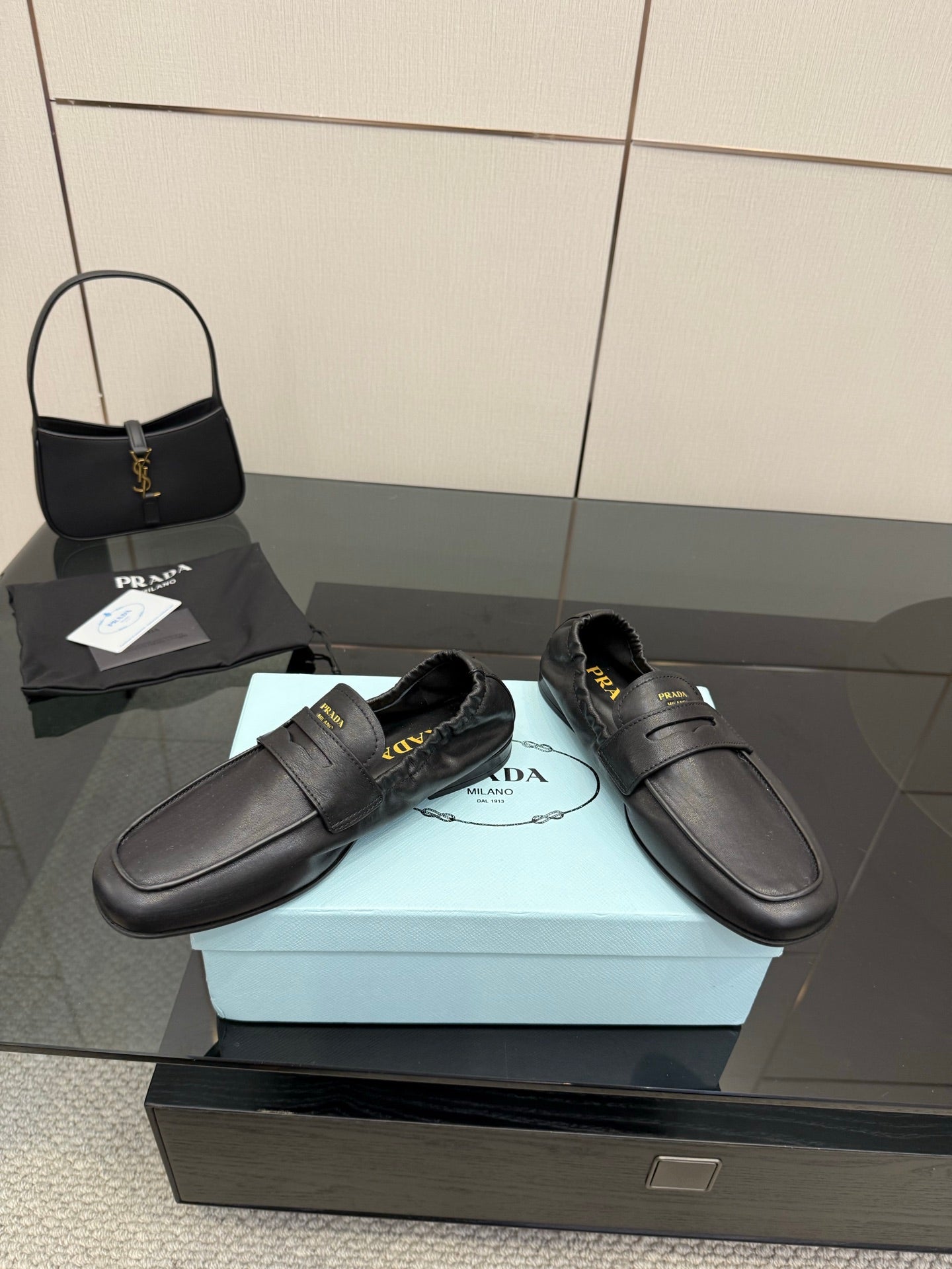 Black leather loafers with front strap and stitched seams, flat heel