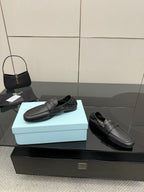Black leather loafers with front strap, smooth slip-on upper, flat sole