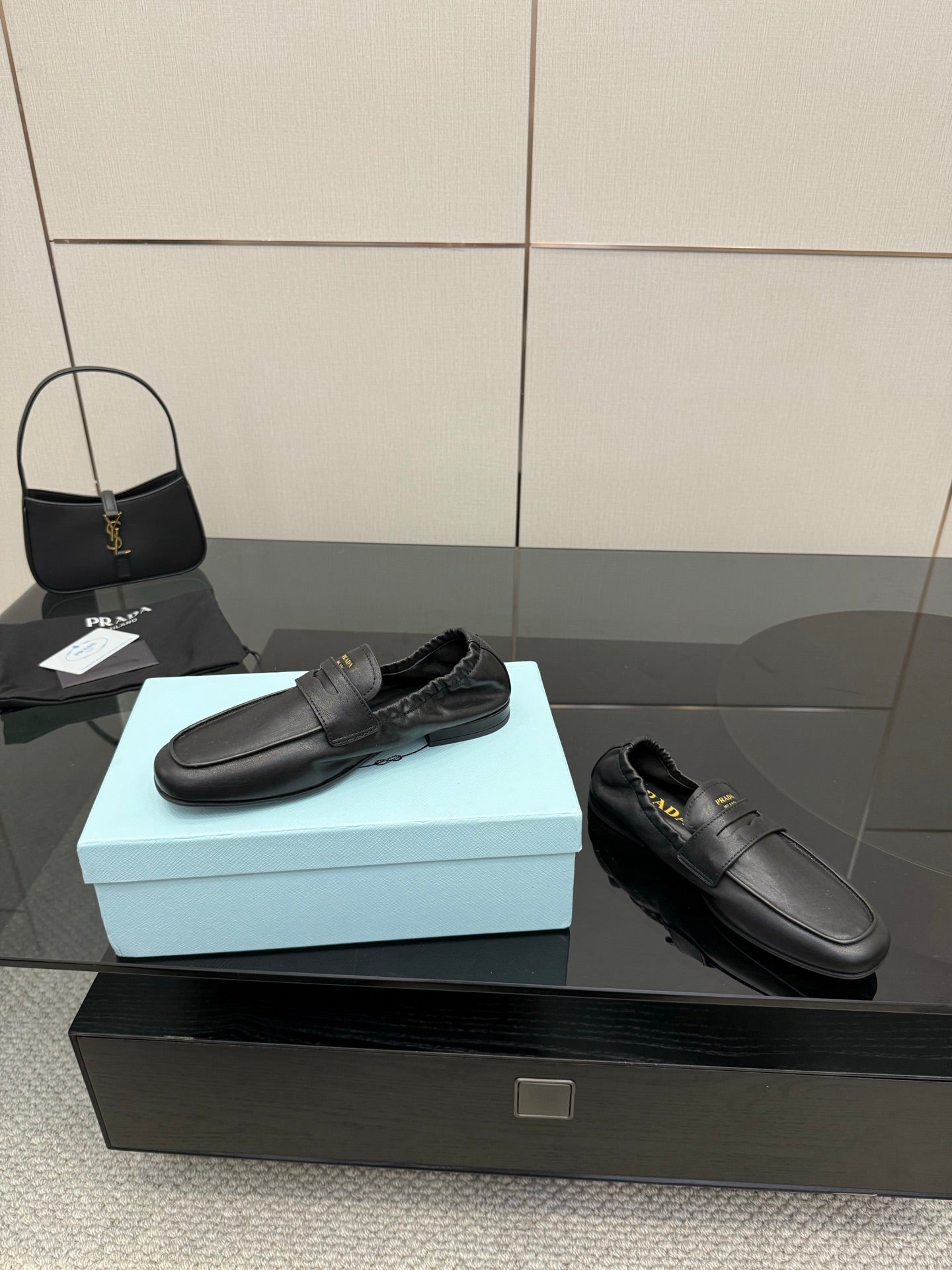 Black leather loafers with front strap, smooth slip-on upper, flat sole