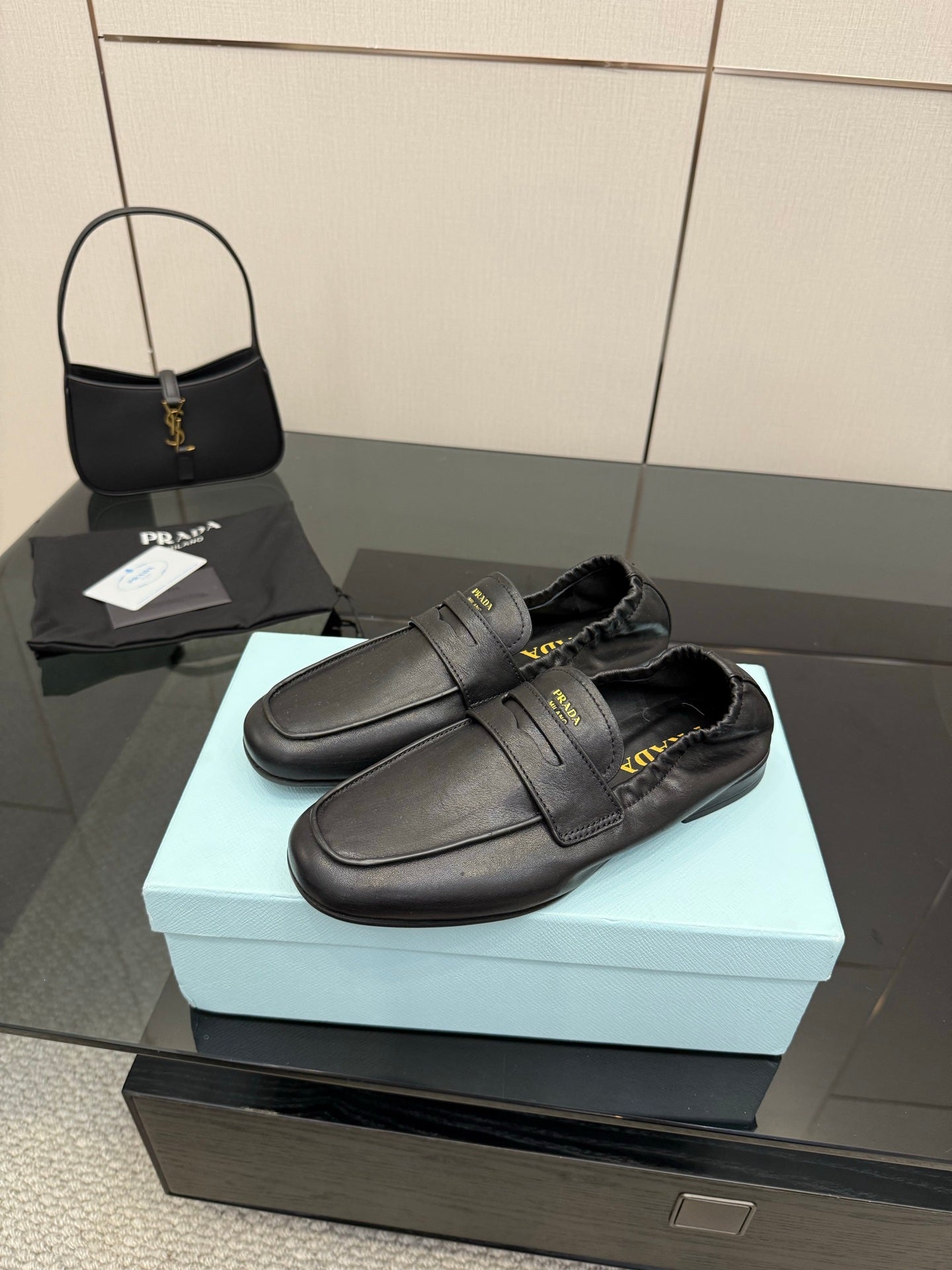 Black leather loafers with front strap and dark lining, low block heel