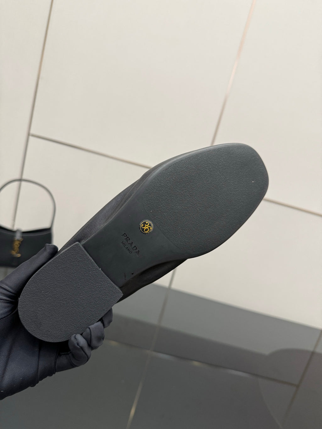 Black leather loafer outsole with textured grip and small logo stamp
