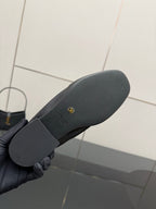 Black leather loafer outsole with textured grip and small logo stamp