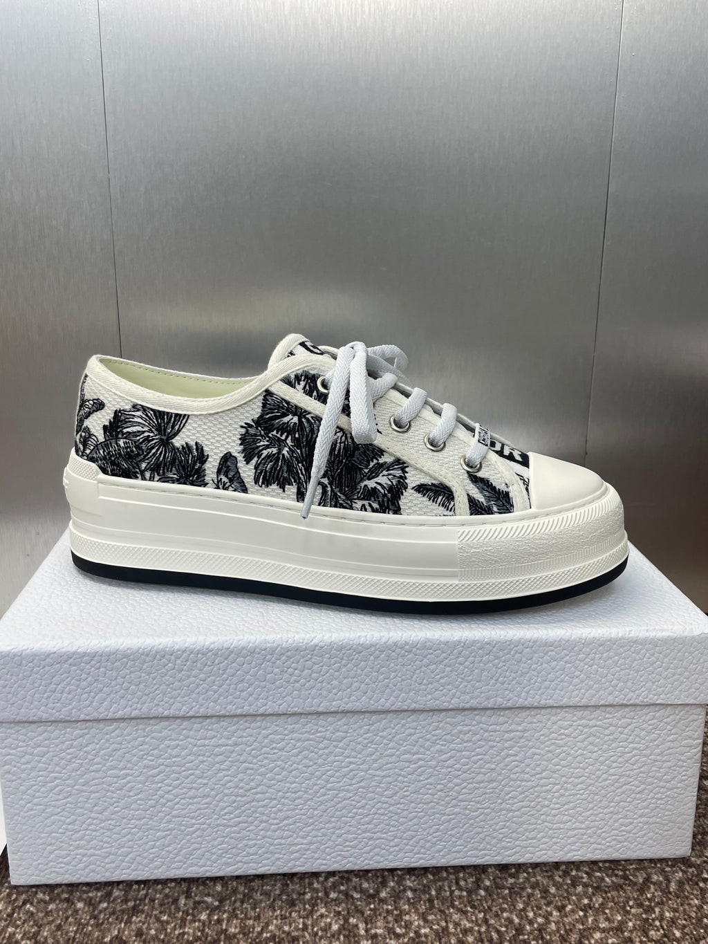 Unisex Dior sneakers on box, black palm-print upper, white laces and rubber sole