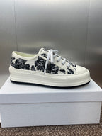 Unisex Dior sneakers on box, black palm-print upper, white laces and rubber sole