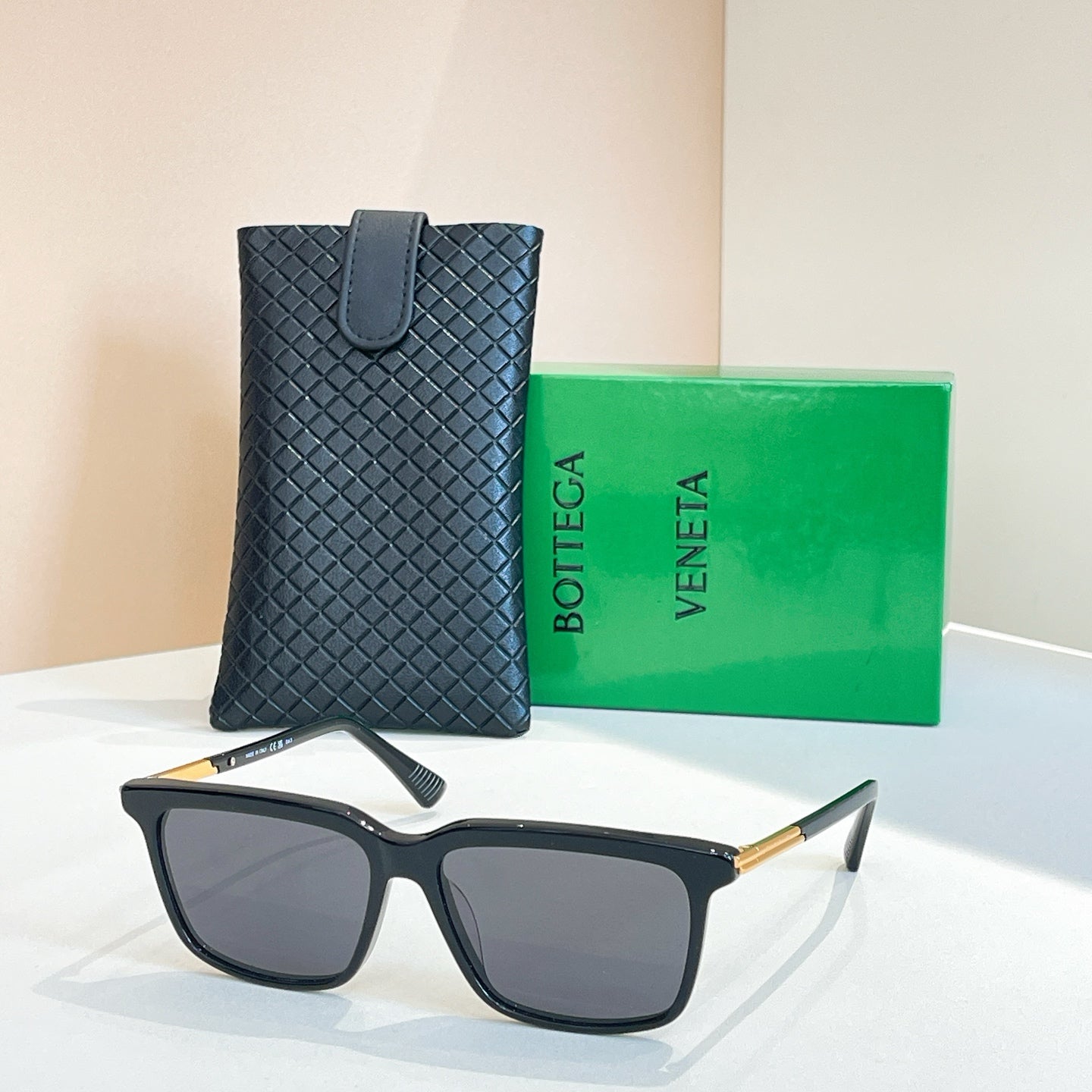 Bottega Veneta glasses with dark frame, dark lenses, gold temples, in leather case