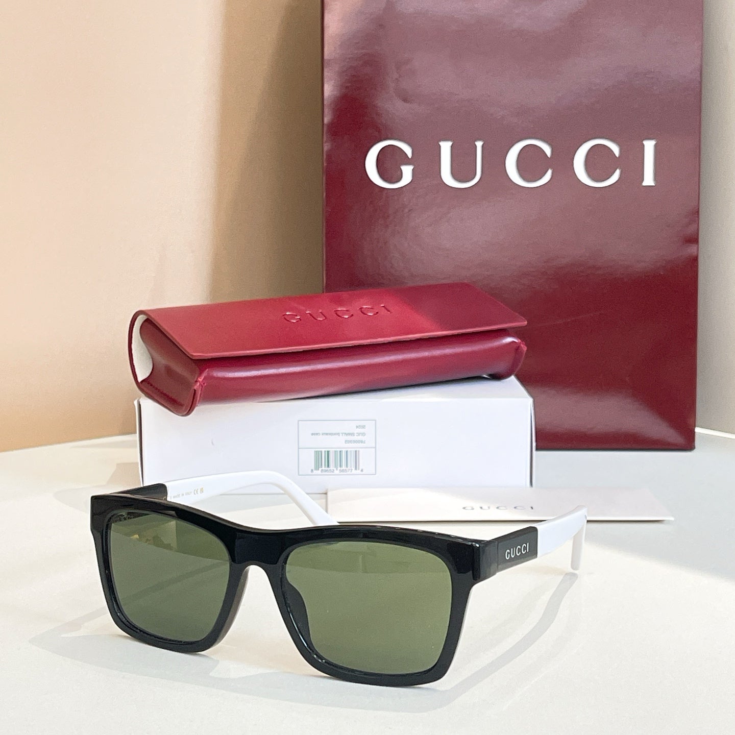 Black square sunglasses with dark green lenses and thick acetate frame.