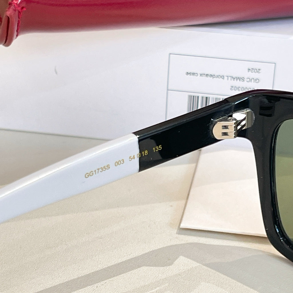 Black sunglasses temple with engraved numbers and gold-tone logo detail.
