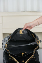 Chanel quilted shoulder bag opened, showing interior with CC emblem and gold hardware