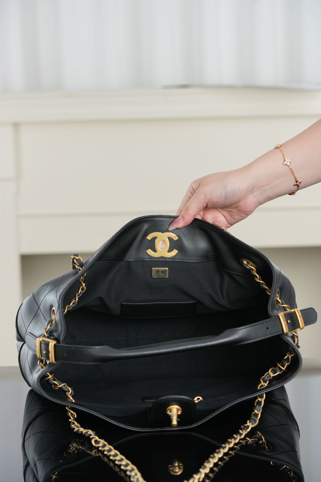 Chanel quilted shoulder bag opened, showing interior with CC emblem and gold hardware