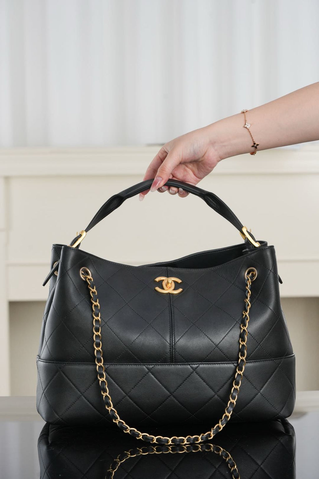Chanel quilted shoulder bag with gold chain handle and dark leather top view