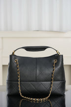 Chanel quilted shoulder bag with gold chain straps and centered CC logo on front
