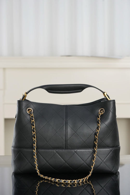 Chanel quilted shoulder bag with gold chain straps and centered CC logo on front