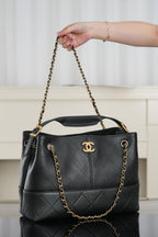 Chanel quilted shoulder bag with chain straps held up, front CC logo detail