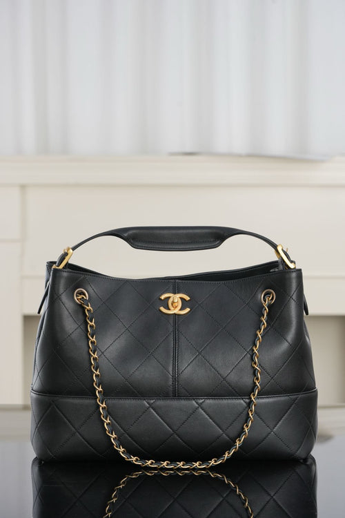 Chanel quilted black bucket bag with chain handles and gold CC logo at center
