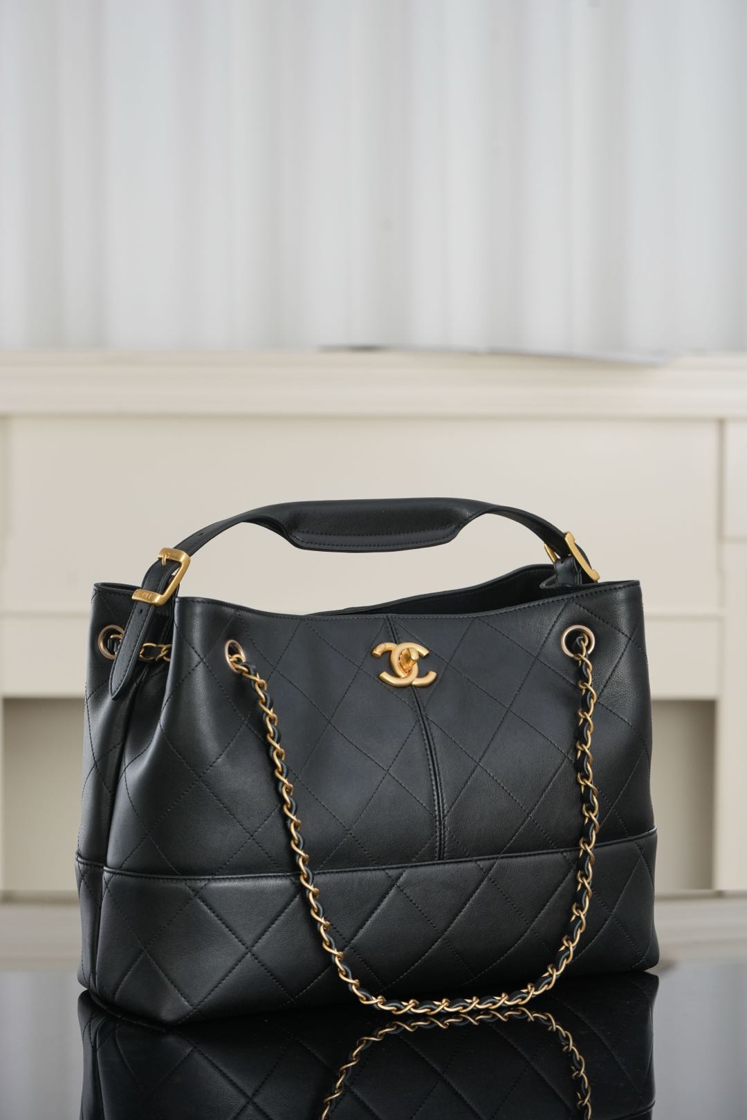 Chanel quilted shoulder bag with gold-tone chain straps and top handle