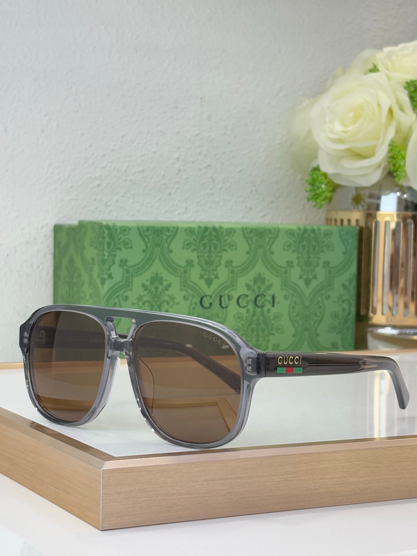 Smoke gray sunglasses with brown lenses and Gucci logo on temple