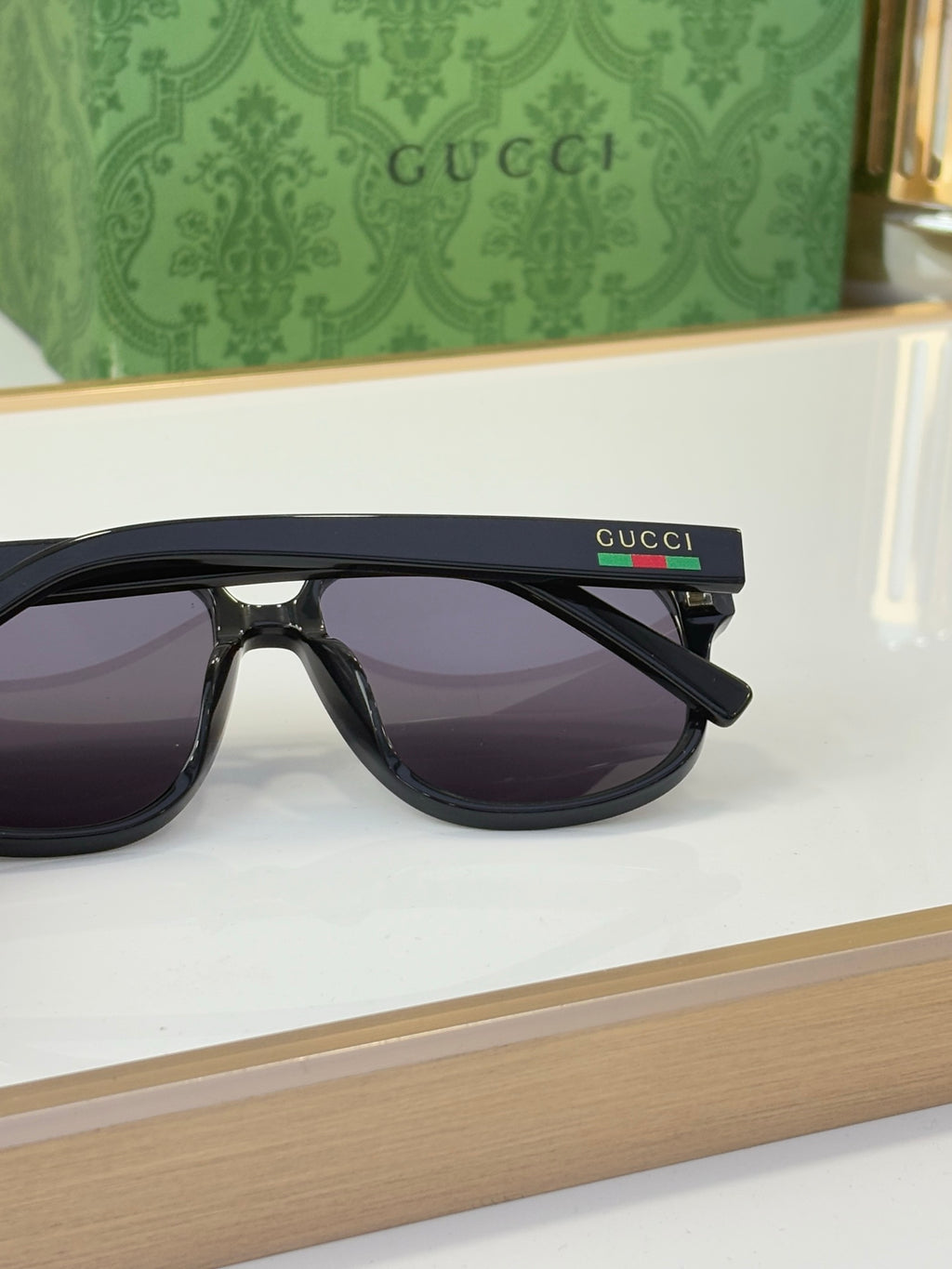 Black sunglasses with dark lenses and Gucci logo on temple, side profile