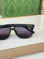 Black sunglasses with dark lenses and Gucci logo on temple, side profile