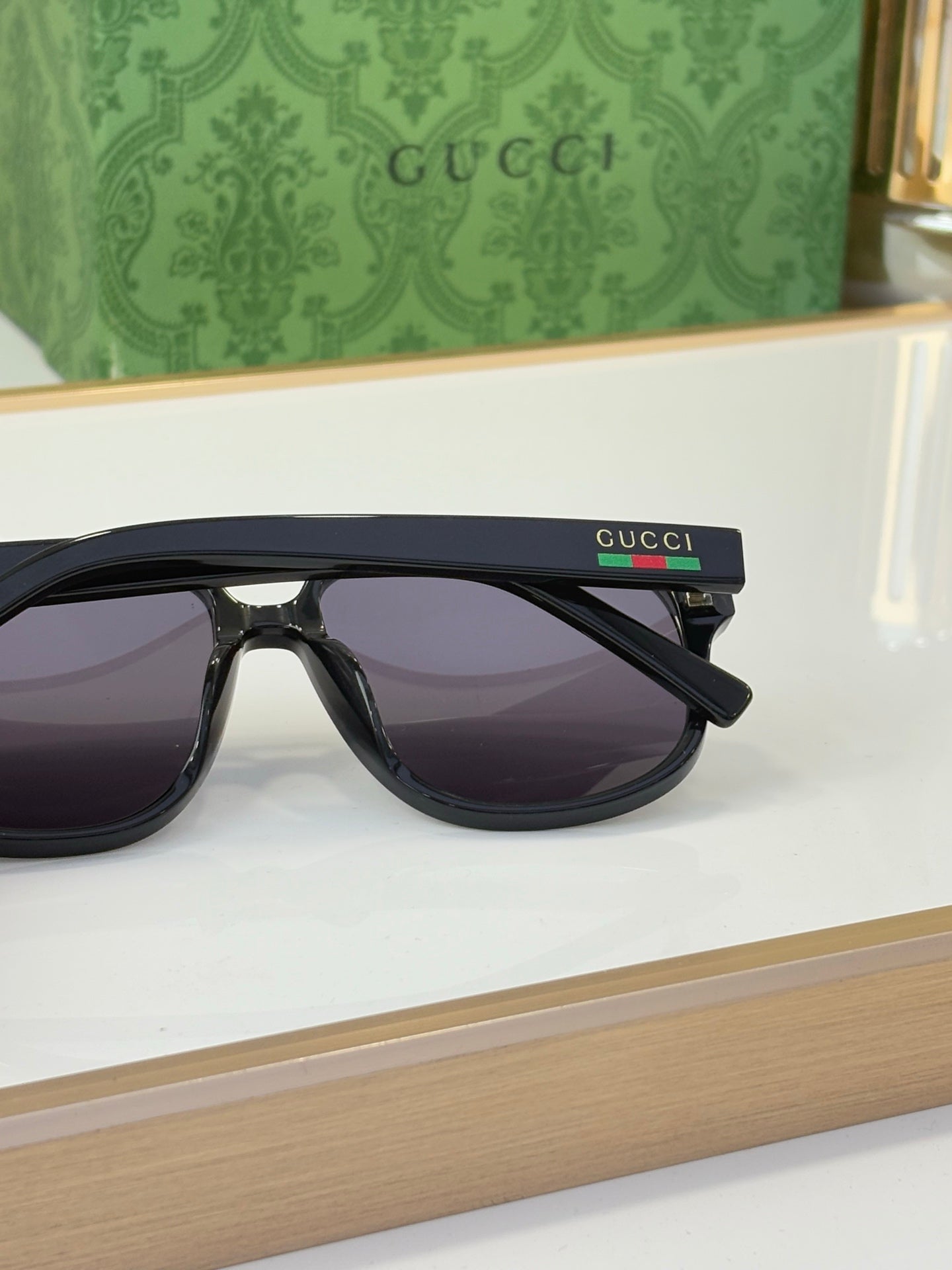 Black sunglasses with dark lenses and Gucci logo on temple, side profile