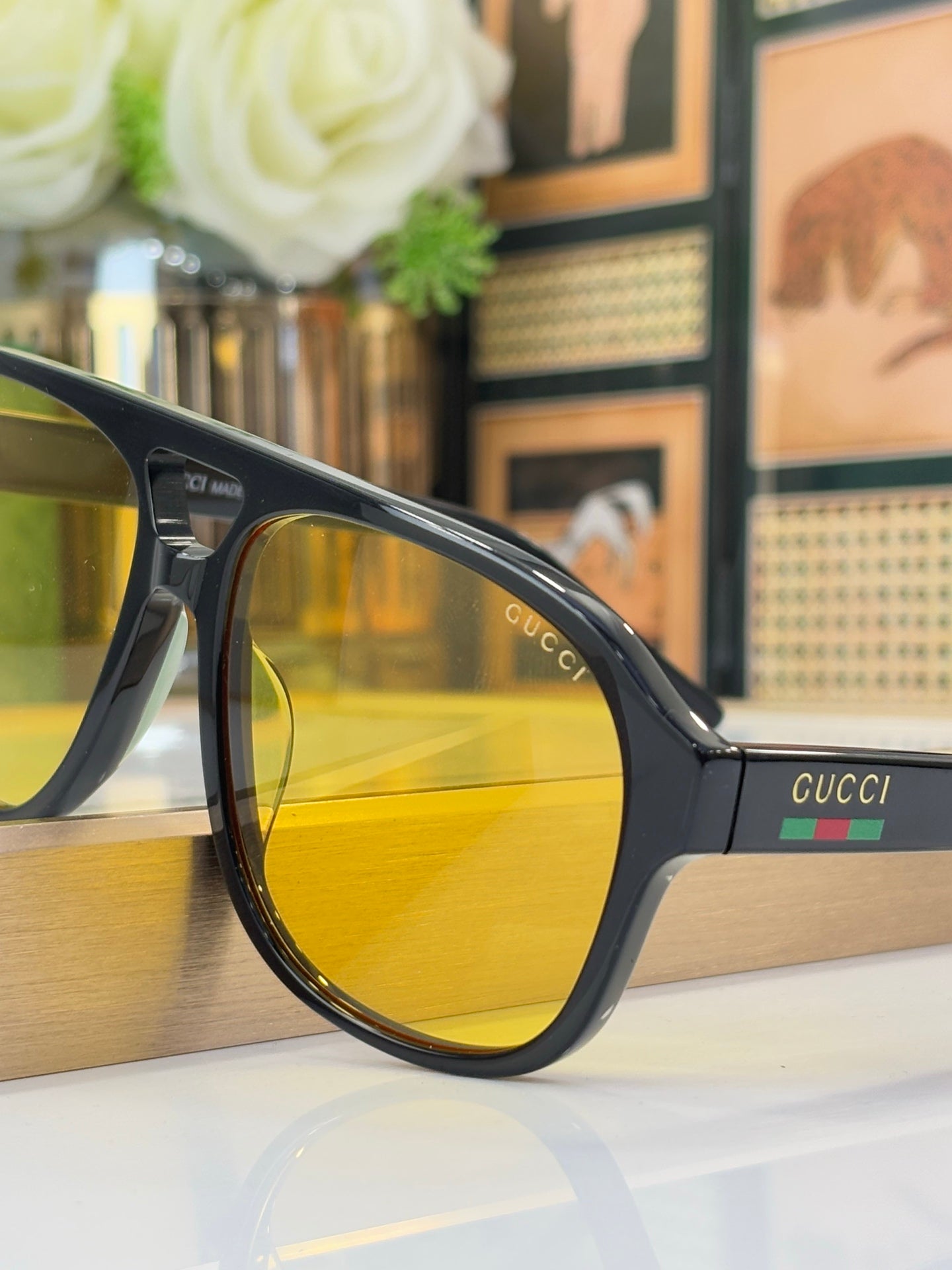 Black sunglasses with yellow lens and Gucci logo on side arm