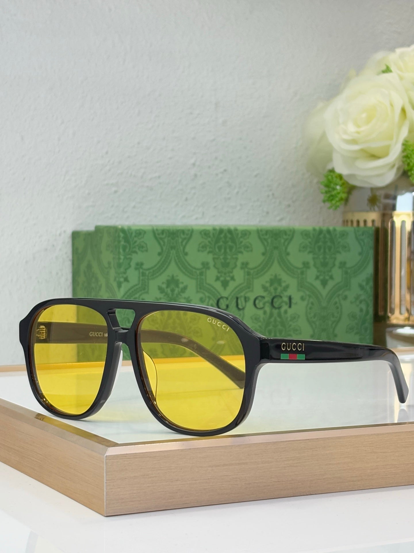 Black sunglasses with yellow lenses and Gucci logo on temple