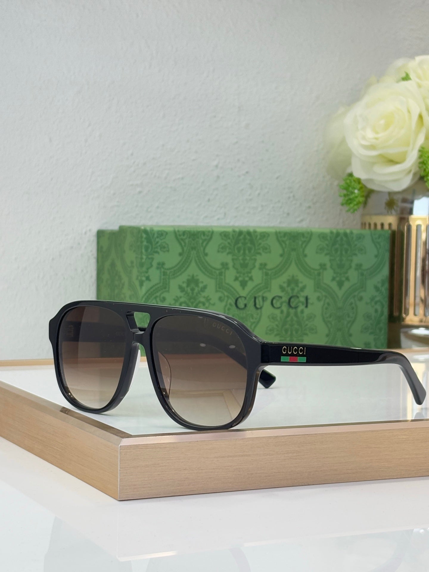 Dark tortoiseshell sunglasses with brown lenses and Gucci logo on temple