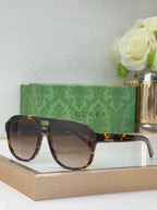 Tortoiseshell sunglasses with brown lenses and Gucci logo on temple