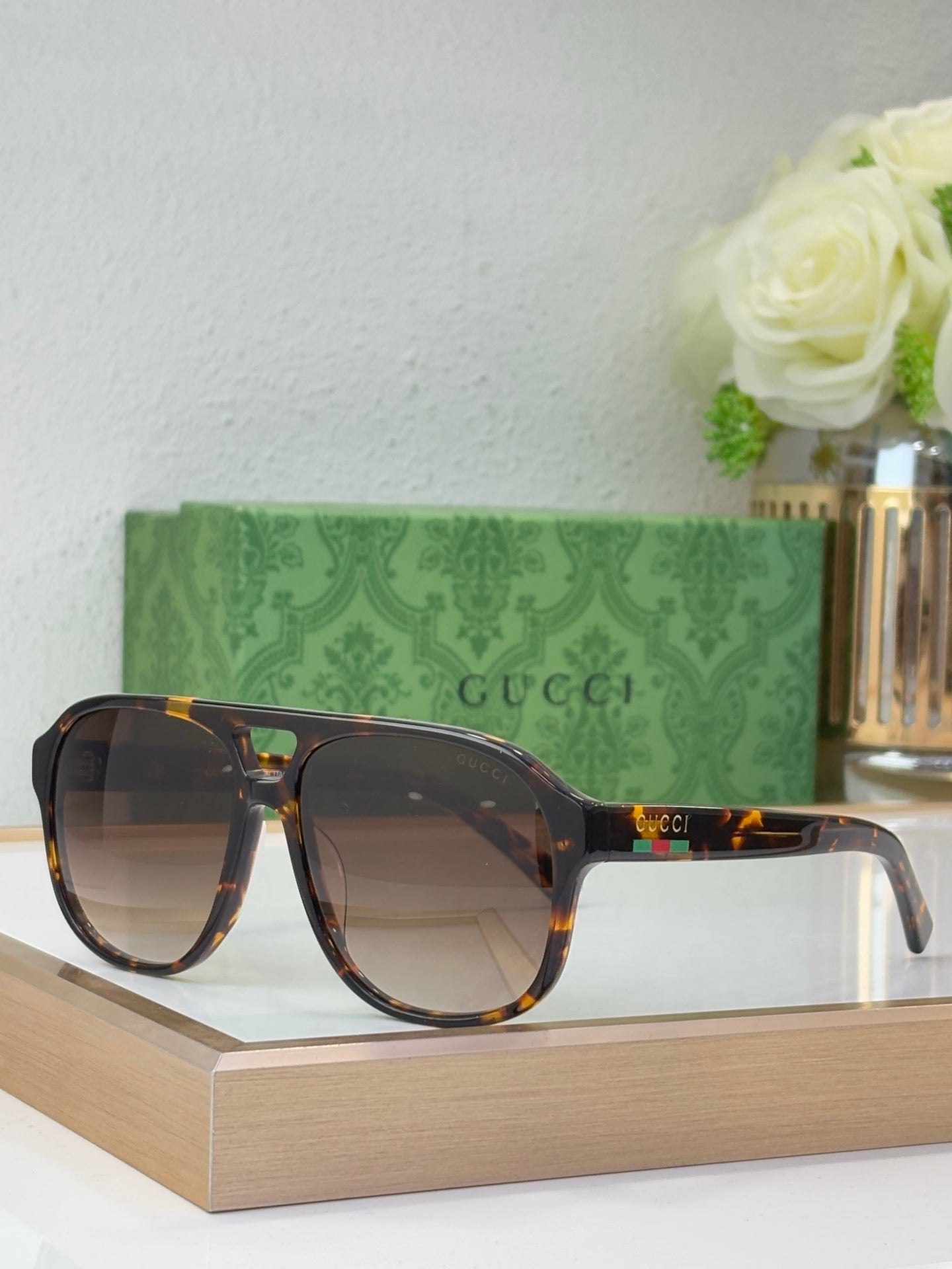 Tortoiseshell sunglasses with brown lenses and Gucci logo on temple