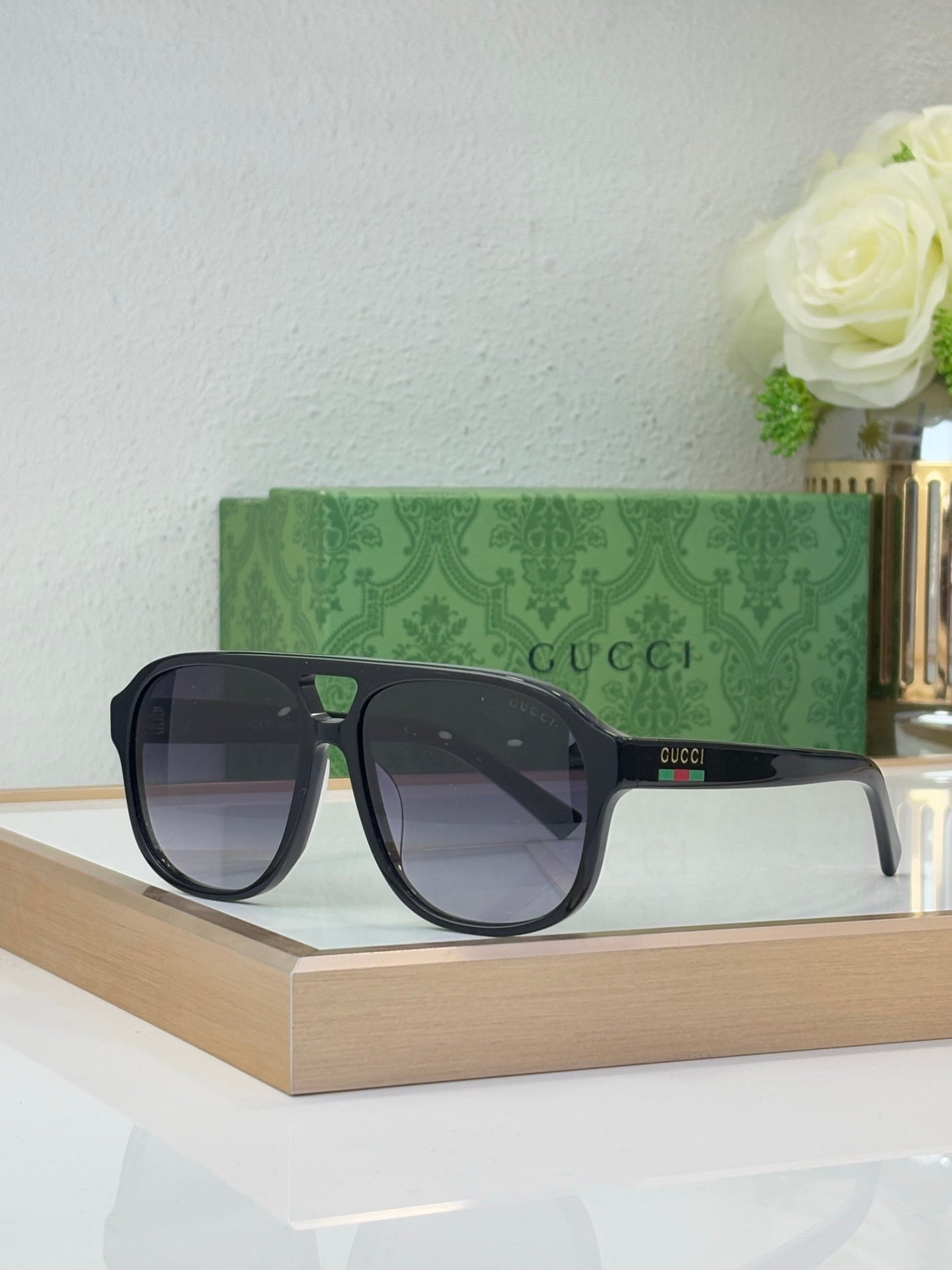 Black sunglasses with dark lenses and Gucci logo on temple, front three-quarter view