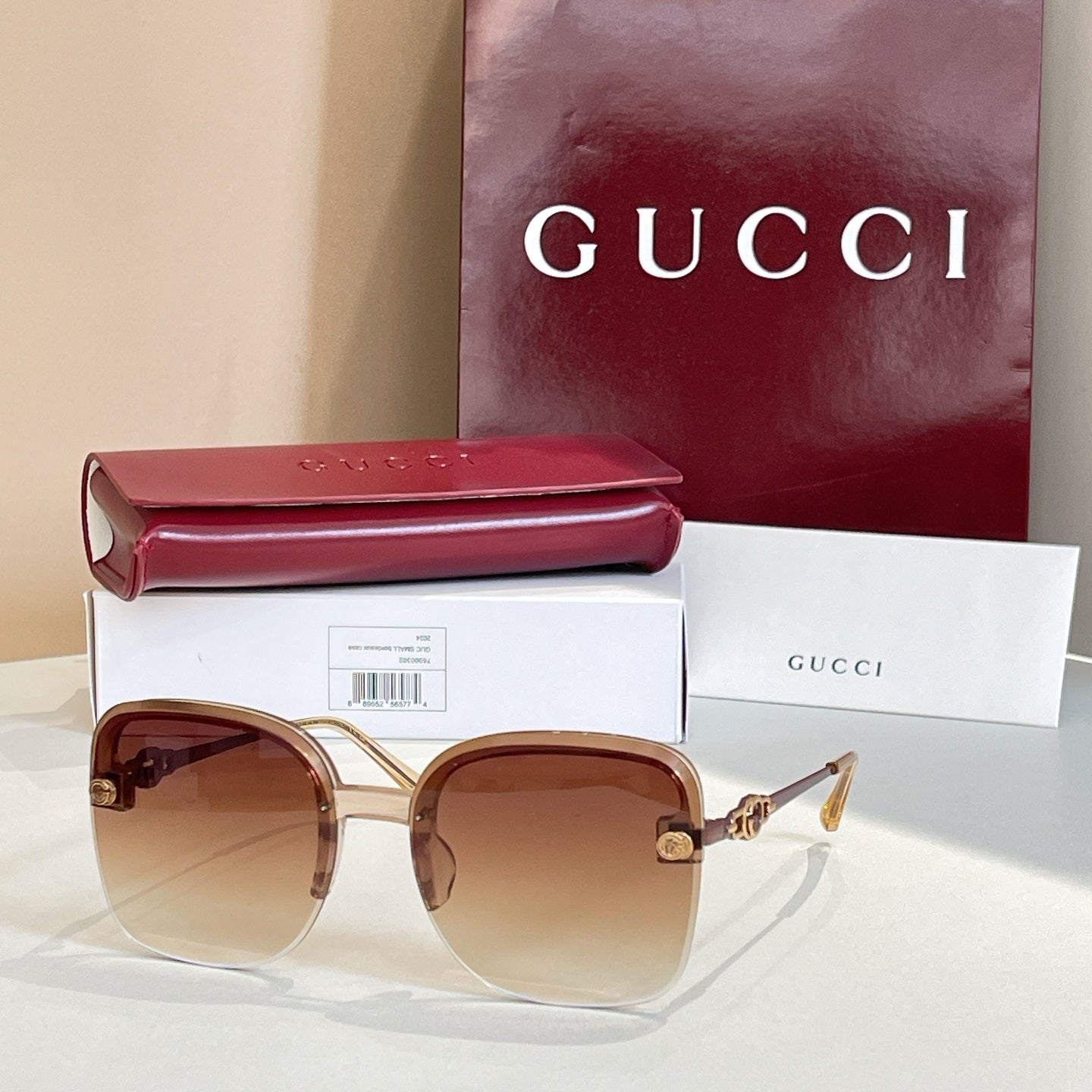 Gucci sunglasses with tan frame, warm gradient lenses, gold logo accents
