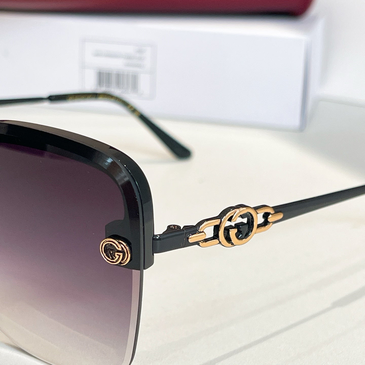 Gucci sunglasses close-up: dark frames with gold logo hinge and temple tips