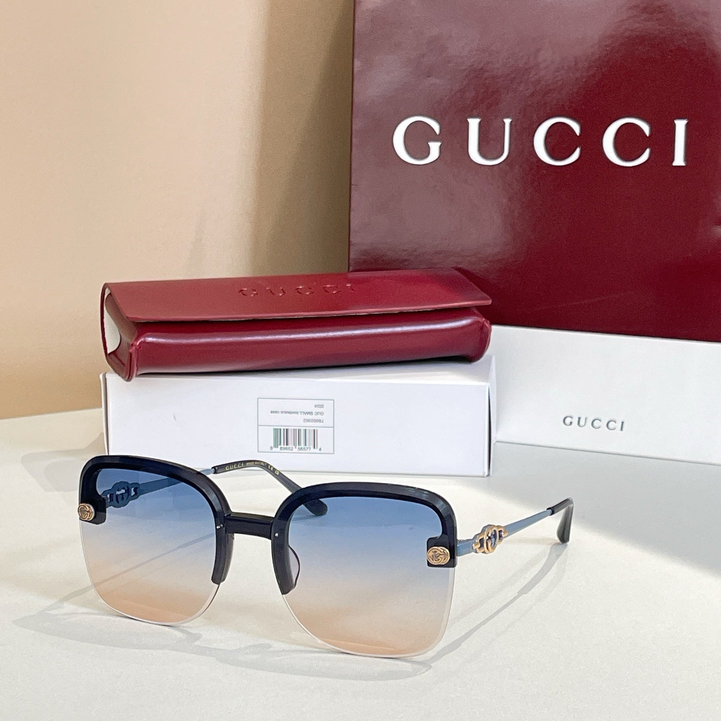 Gucci sunglasses with dark frame, gradient amber lenses, gold hinge logo