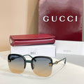 Gucci sunglasses with dark frame, gradient amber lenses, gold logo accents