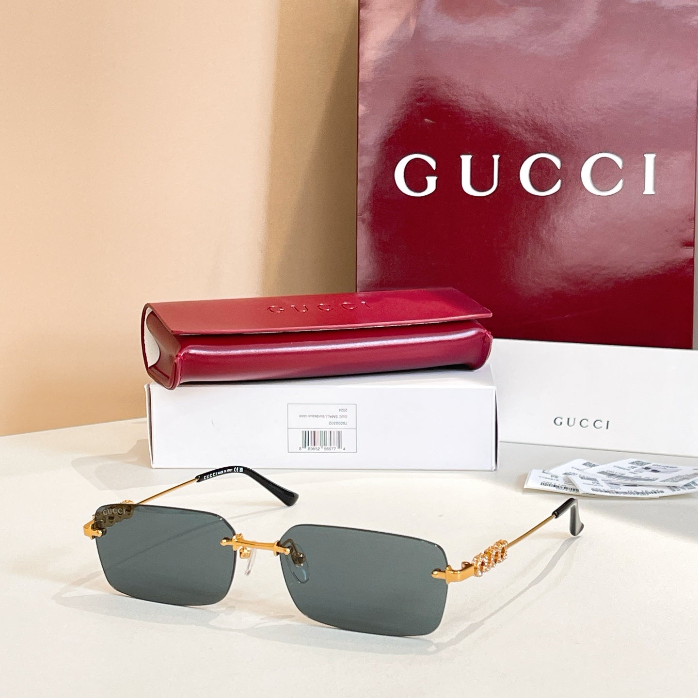 Gucci square sunglasses with dark gray lenses and gold-tone embellished frame