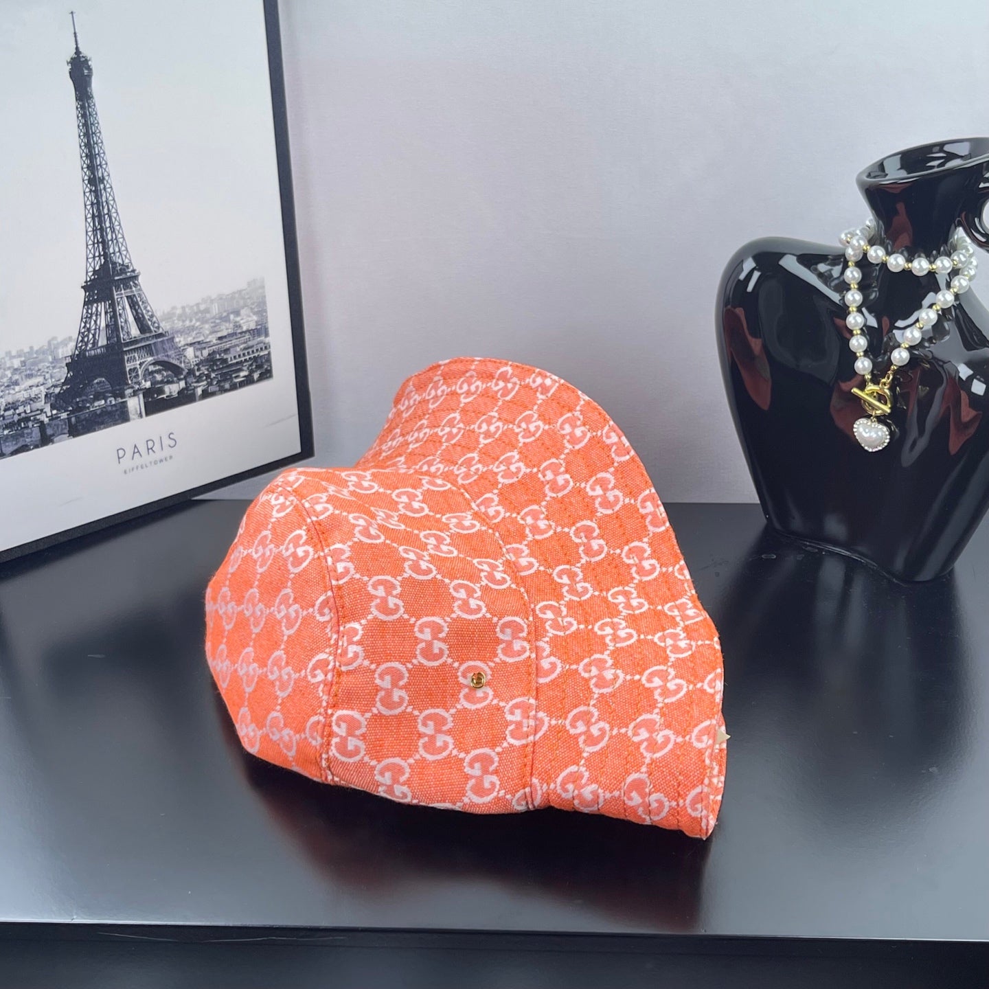 Orange GG-print bucket hat, side profile with curved brim
