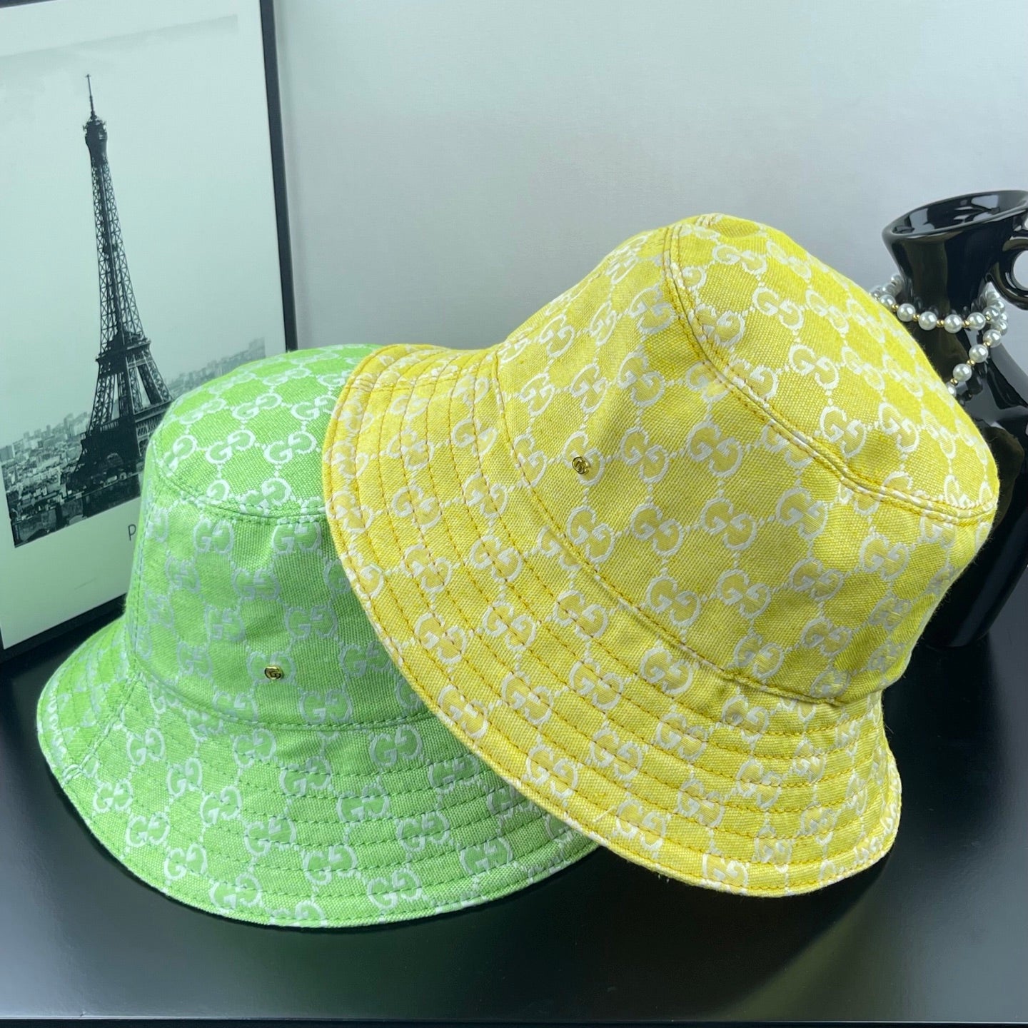 Gucci bucket cap bright yellow with GG monogram, shown beside another similar hat