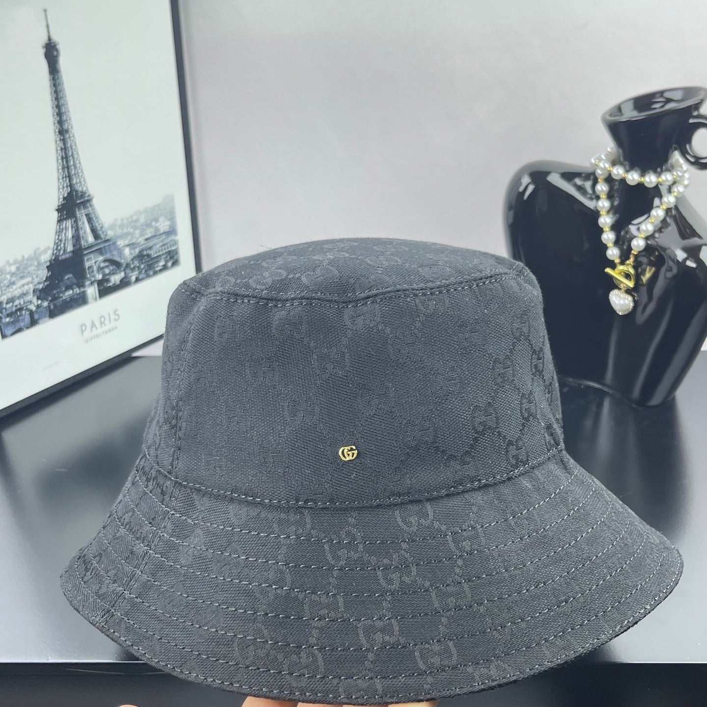 Gray GG monogram bucket hat, front view, small gold GG pin