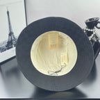 Gray bucket hat with cream lining and hanging product tags visible inside