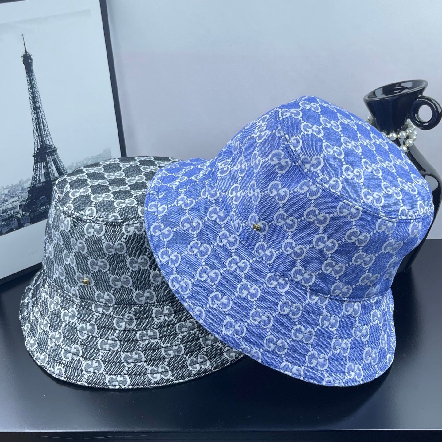 Bucket hats set with GG monogram patterns, blue and gray, side by side