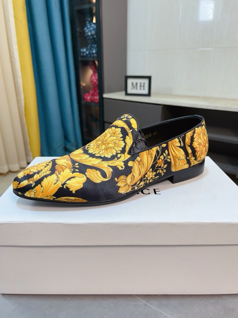 Yellow baroque floral slip-on loafer with black trim and low-profile sole.