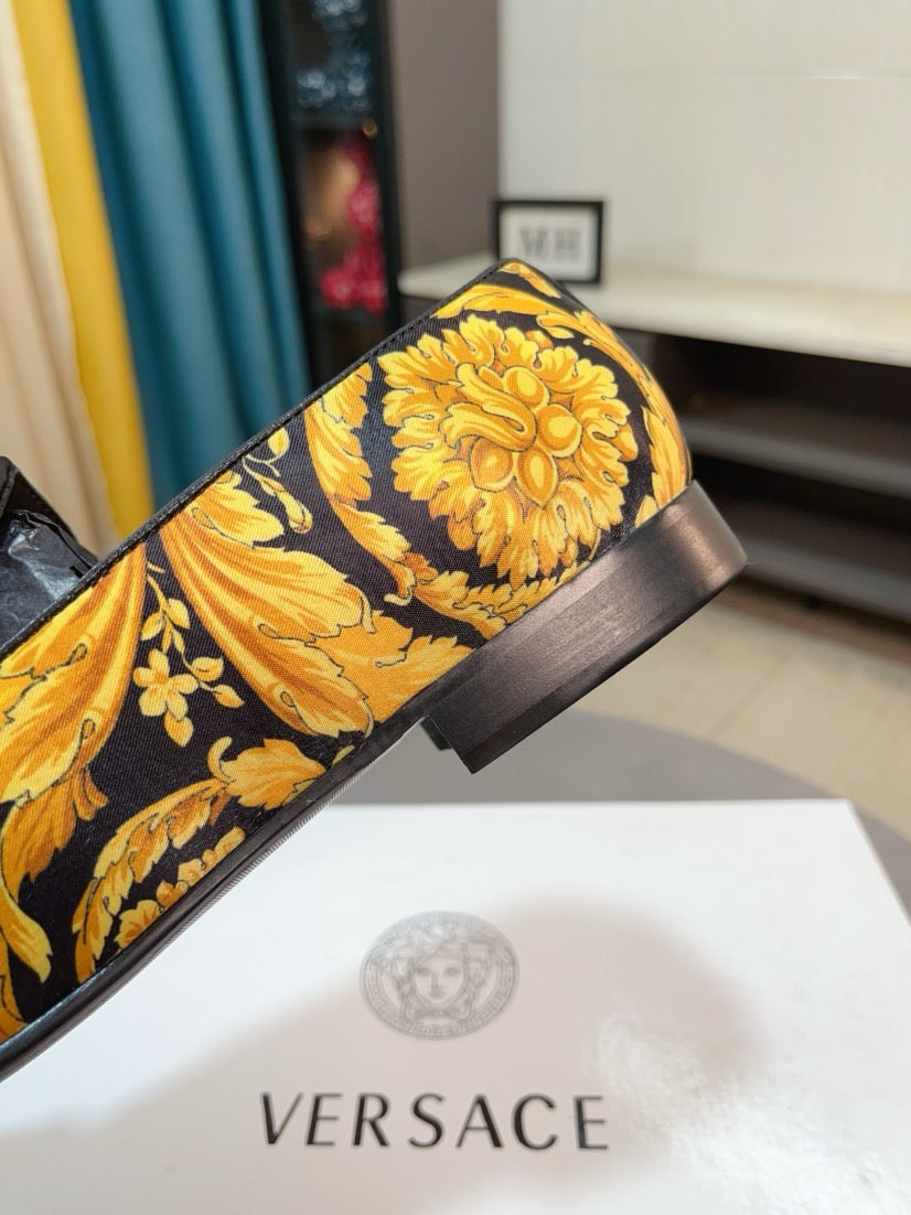 Floral loafer with black heel and band, yellow blossoms on dark upper.