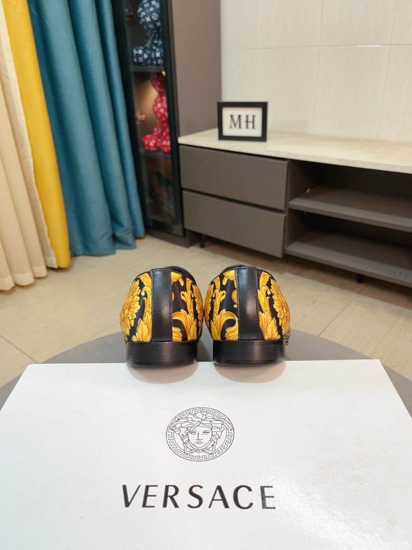 Back view of floral slip-on loafers showing black heels and dark yellow pattern.