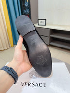 Black velvet loafer sole with embossed branding and logo markings
